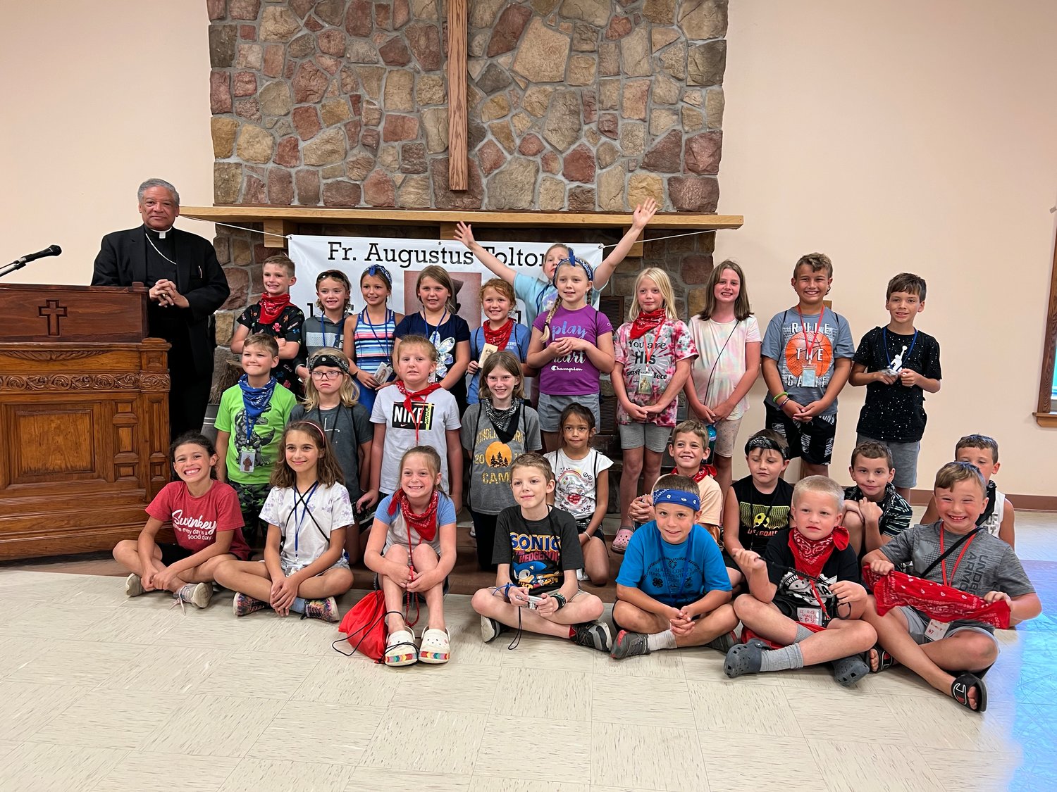 Auxiliary Bishop Joseph N. Perry of Chicago, postulator for the sainthood cause of Venerable Father Augustus Tolton, gathers for a group photo with children during Camp Tolton at Camp Jo’Ota in Clarence.